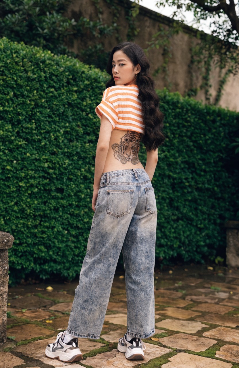 Detailed black tiger tattoo on a woman's lower back, viewed from behind