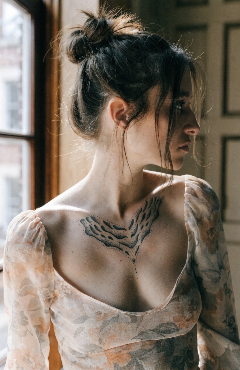 Delicate black tiger stripe tattoo forming a choker necklace across woman's upper chest and collarbone