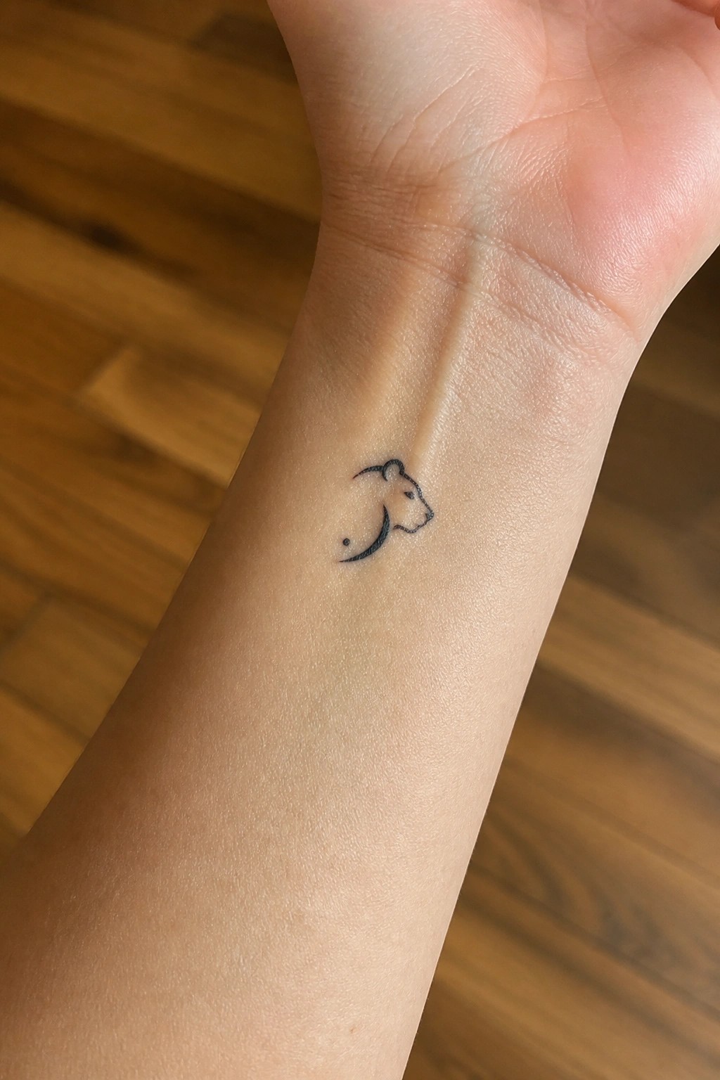 Small minimalist lioness head outline tattoo on the inner wrist