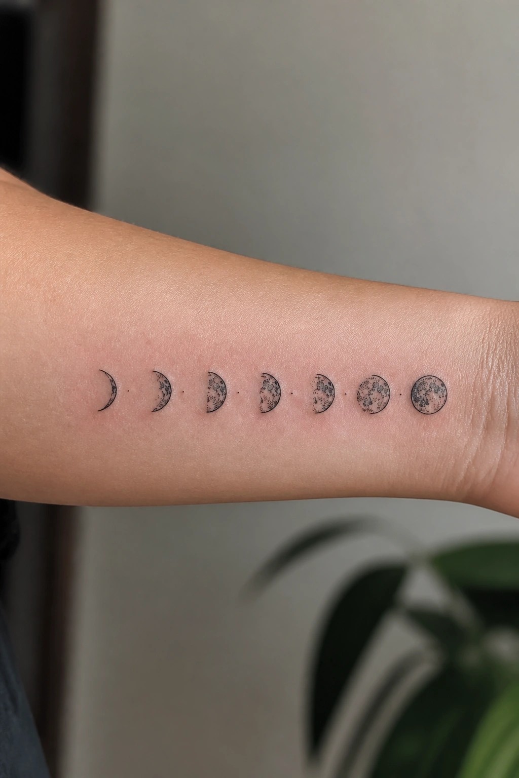 Moon phases tattoo inked on forearm from crescent to full moon
