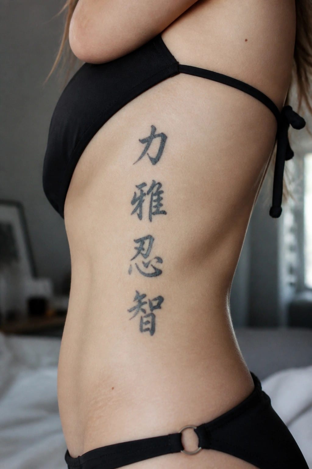 Vertical stack of four Chinese characters in black ink on the side of the torso