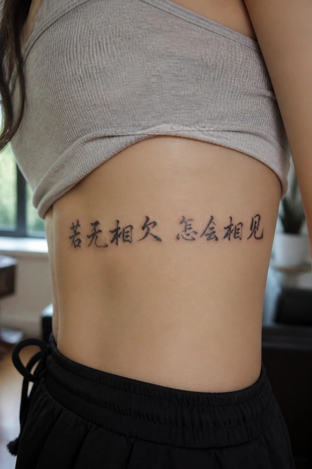 Black Chinese calligraphy tattoo placed horizontally on the side of the torso