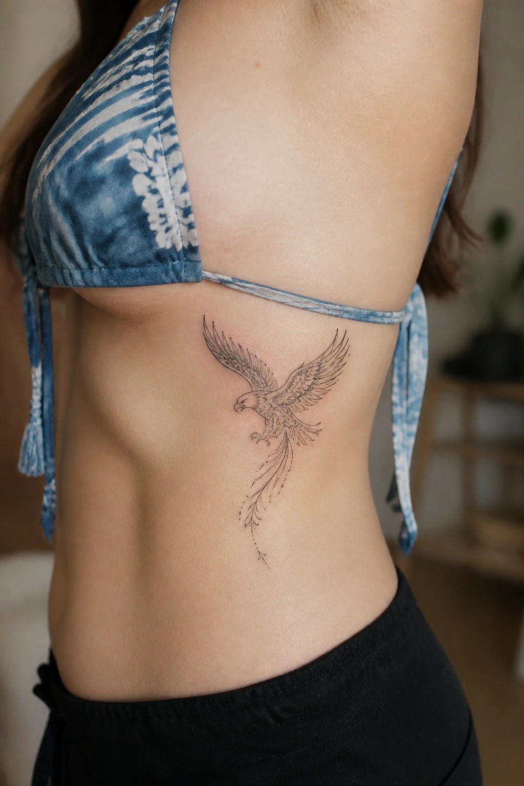 Fine line eagle tattoo on the side torso showing a bird in flight with spread wings in black ink.