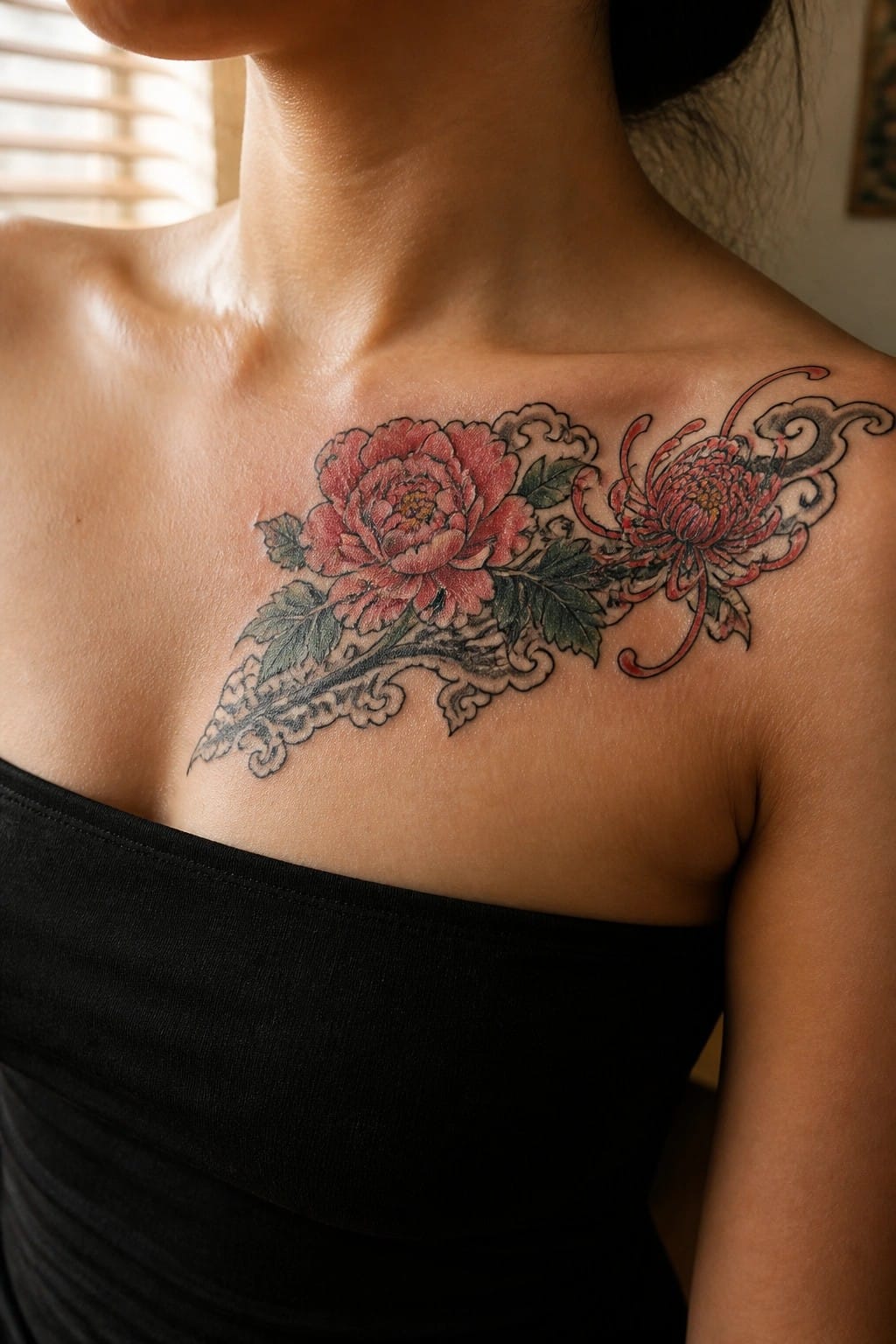 Red peony and chrysanthemum tattoo on chest above black strapless top