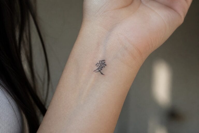 23 Chinese Character Tattoo Ideas for Women That Feel Deeply Personal Wrist with small black tattoo of Chinese character for love