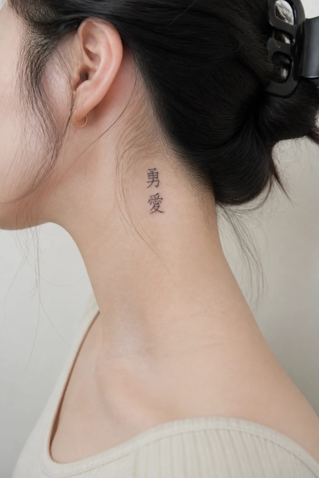 Small vertical Chinese character tattoo on the side of a woman's neck in simple black ink
