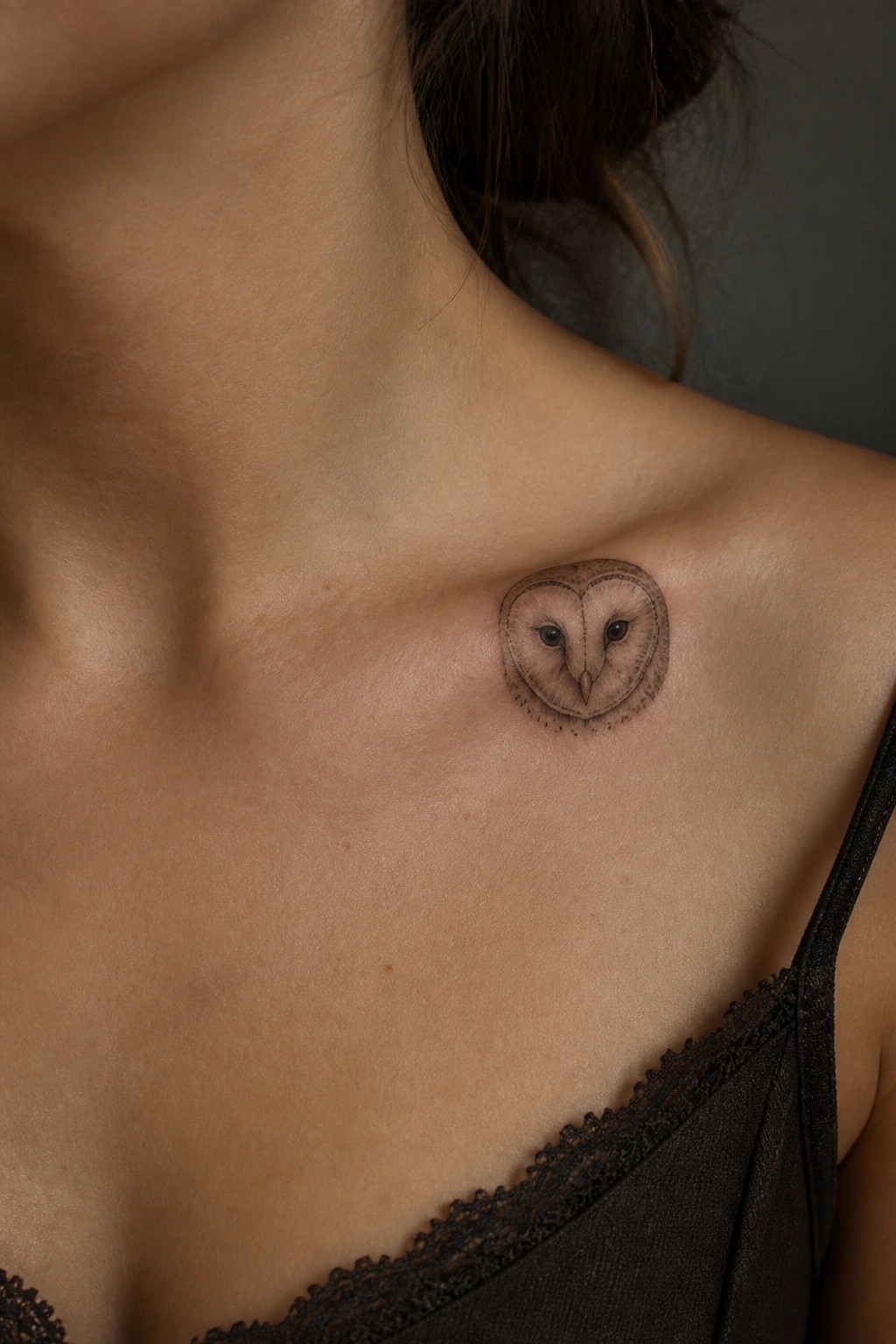 Small circular barn owl tattoo on the collarbone area