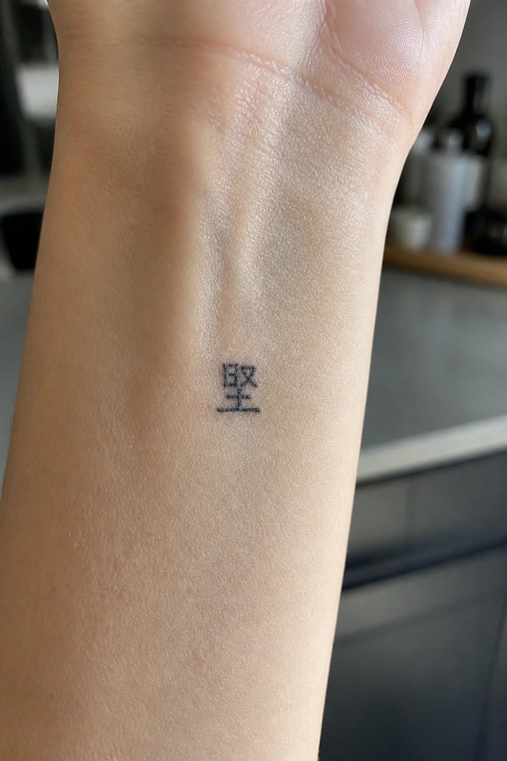 Small black Chinese characters tattoo on the inner wrist