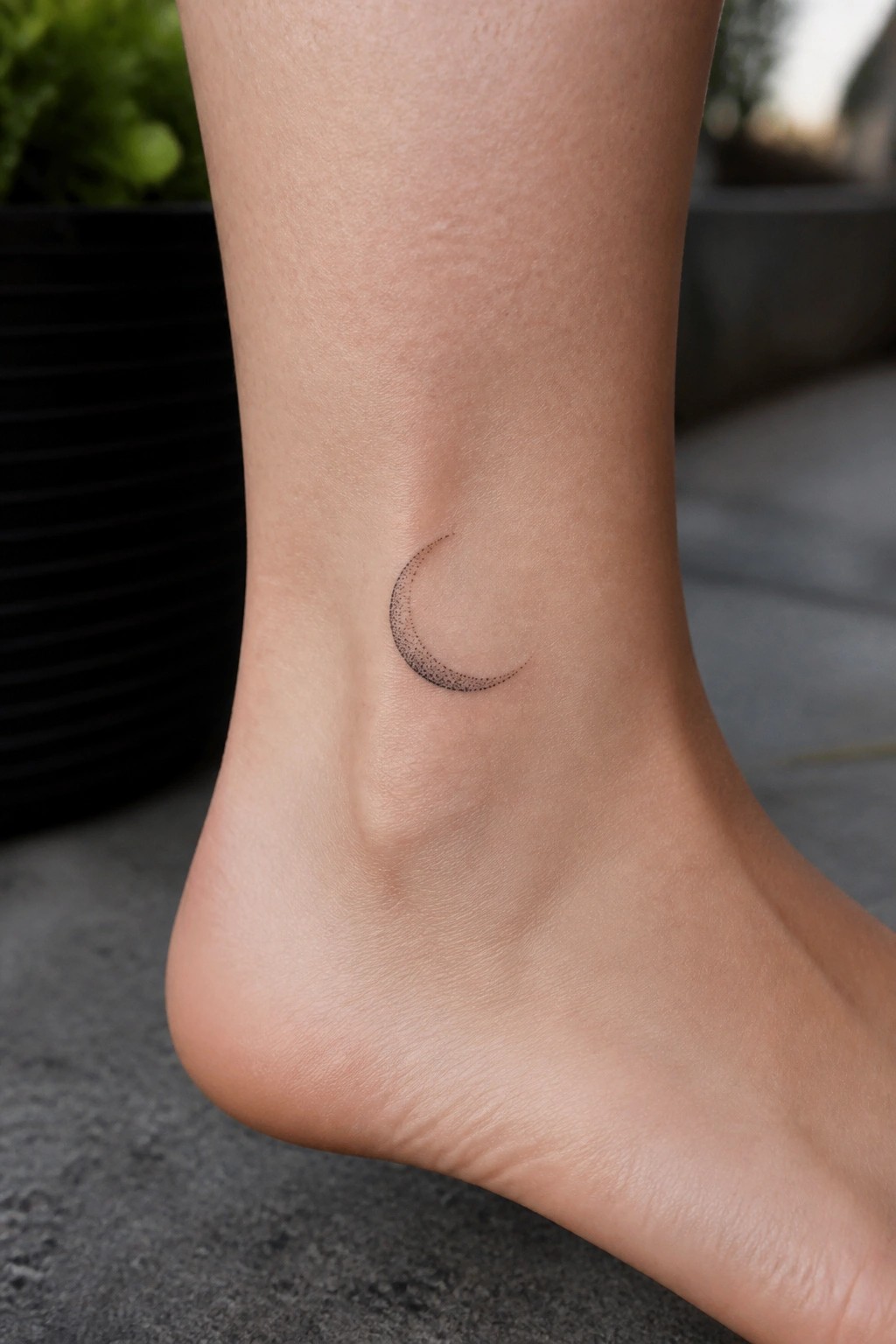 small dotted crescent moon tattoo on the inner ankle