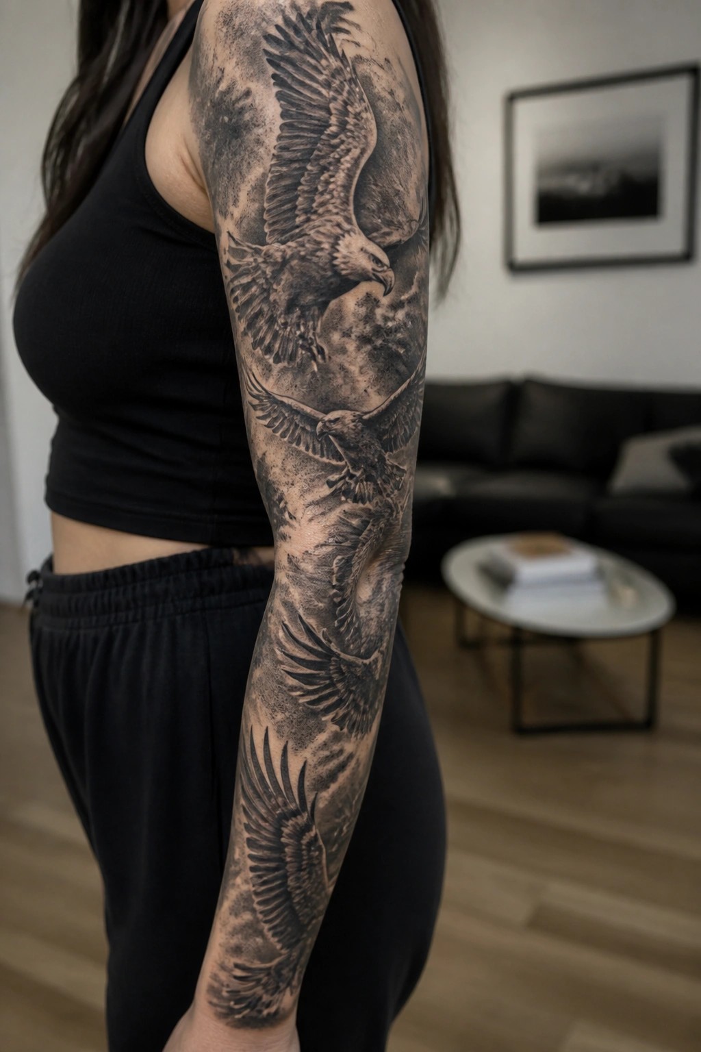 Woman's arm with large black-and-gray eagle tattoo in living room