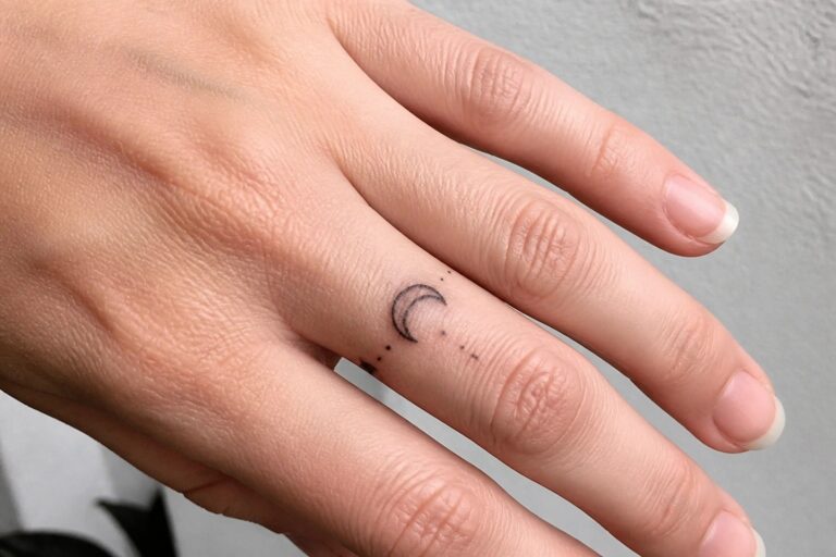 18 Chic Finger Tattoos for Women Perfect for a Subtle Statement Hand with manicured nails and crescent moon stars tattoo on ring finger.