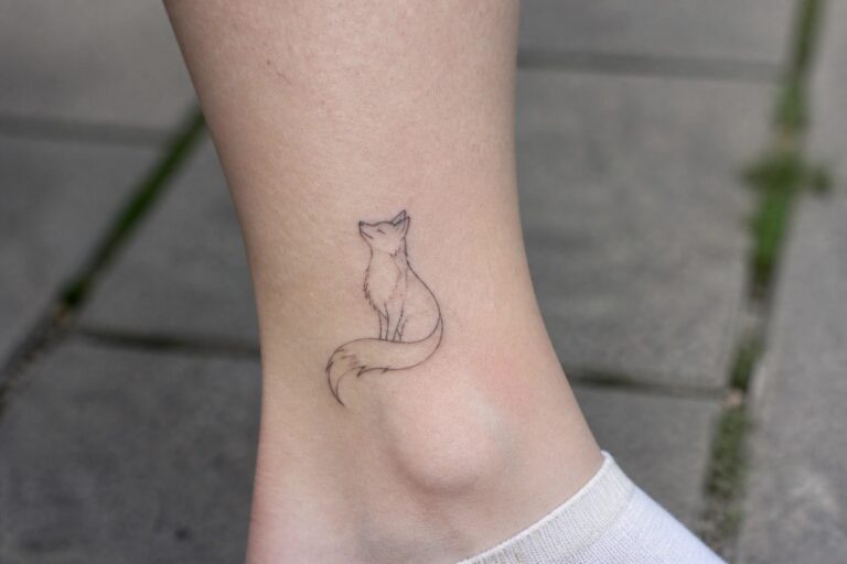 18 Elegant Fine Line Animal Tattoos for a Clean Modern Look Fine line tattoo of a small sitting fox on the ankle