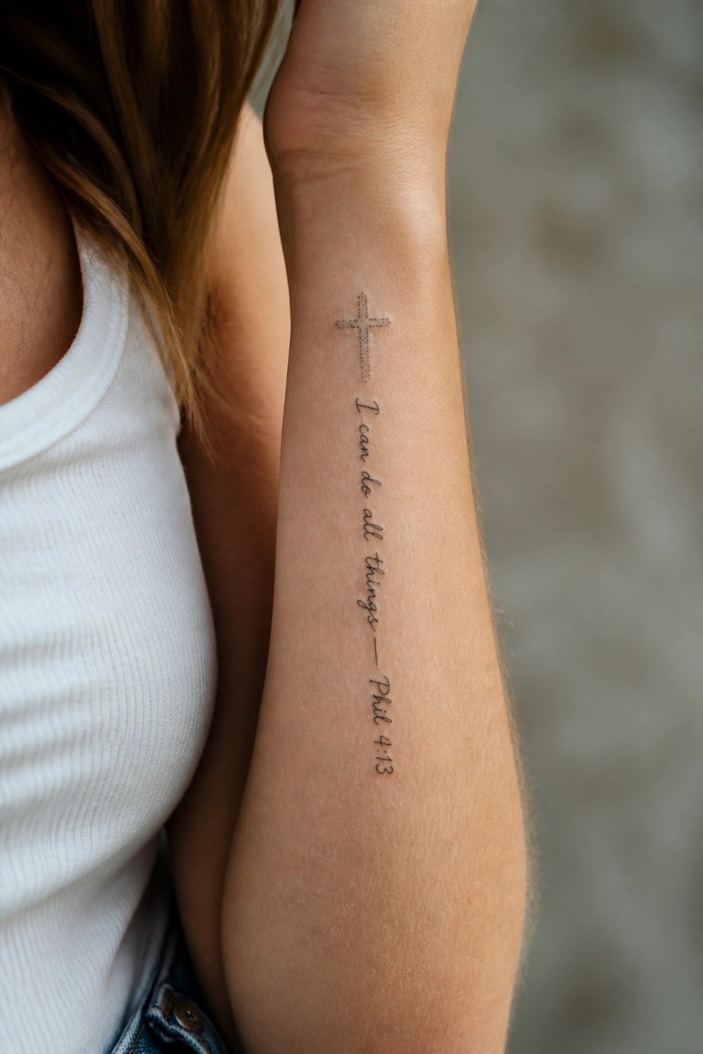 Arm tattoo of cross above 