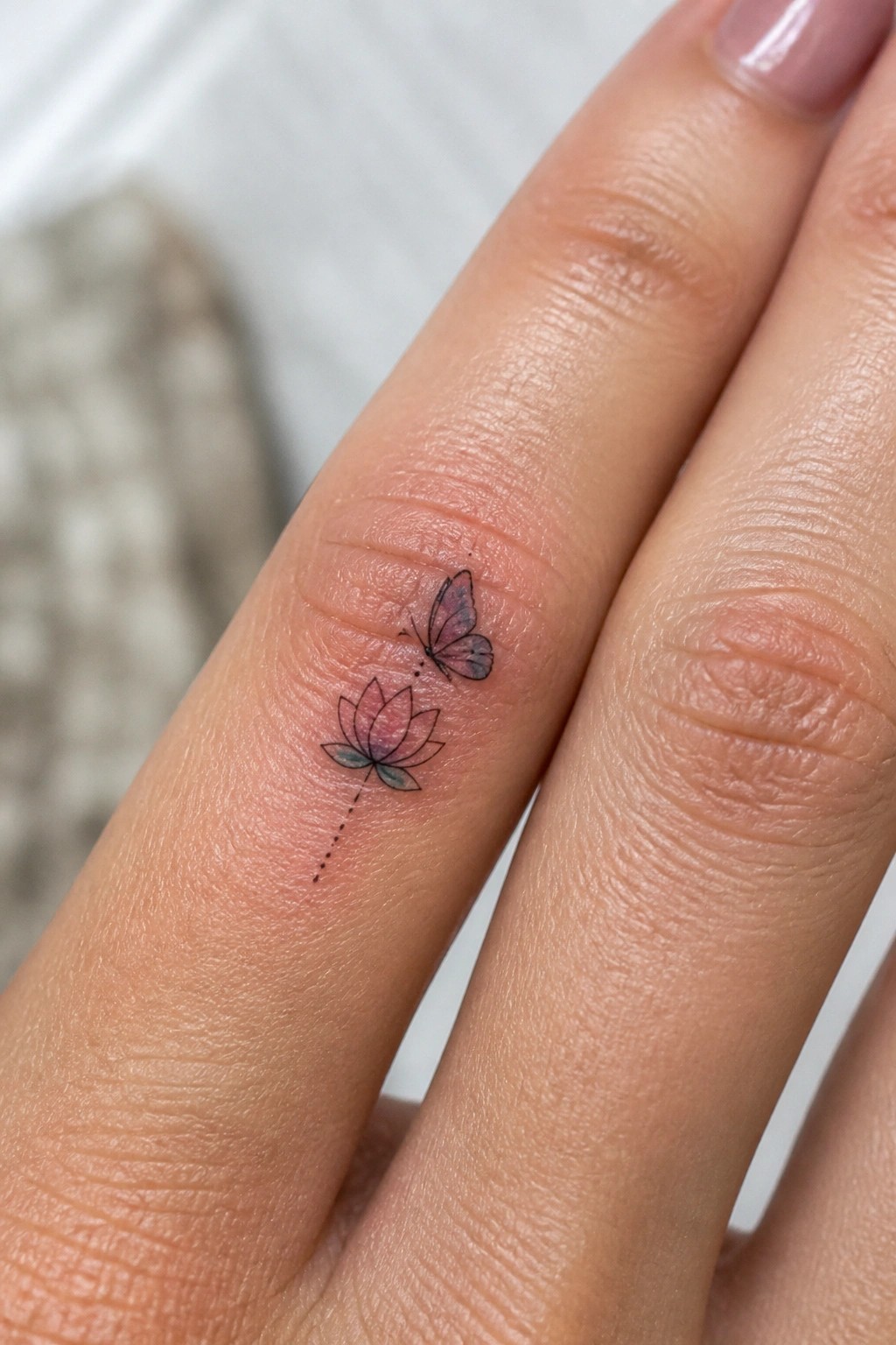 Colorful lotus flower and butterfly tattoo with dotted lines on finger