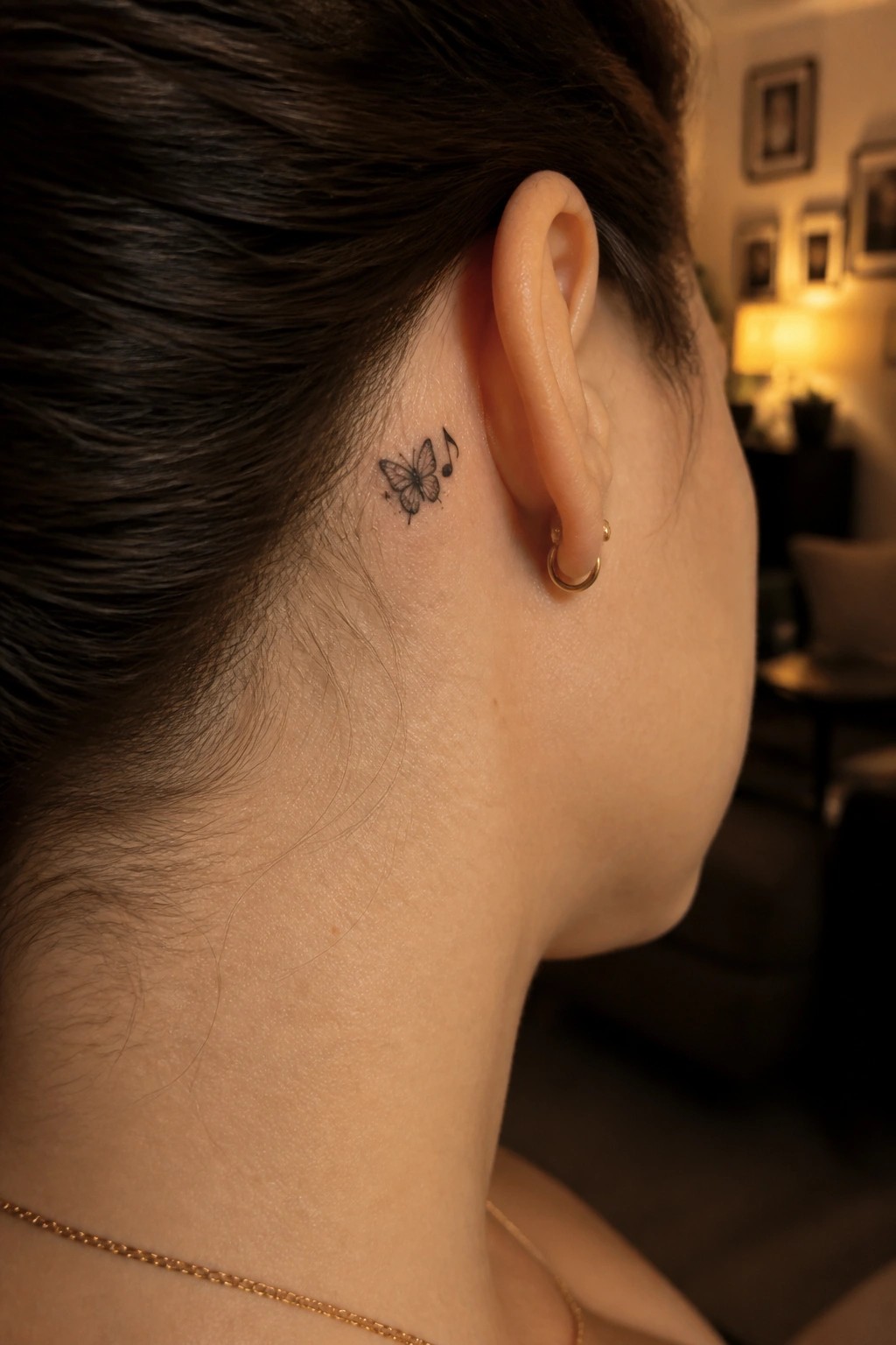 Side view of neck and ear with butterfly music note tattoo and gold hoop earring