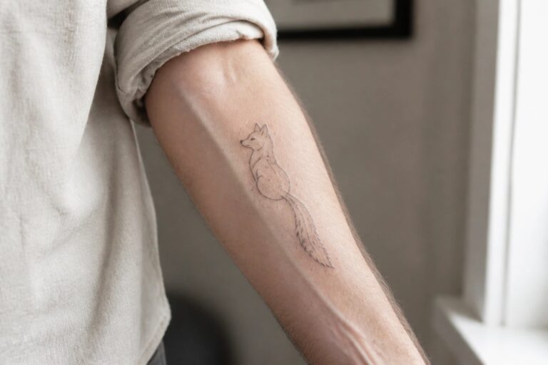 21 Classic Small Animal Tattoos for Men Using Clean Fine Line Artwork Fine line fox tattoo on forearm below rolled-up white shirt sleeve.