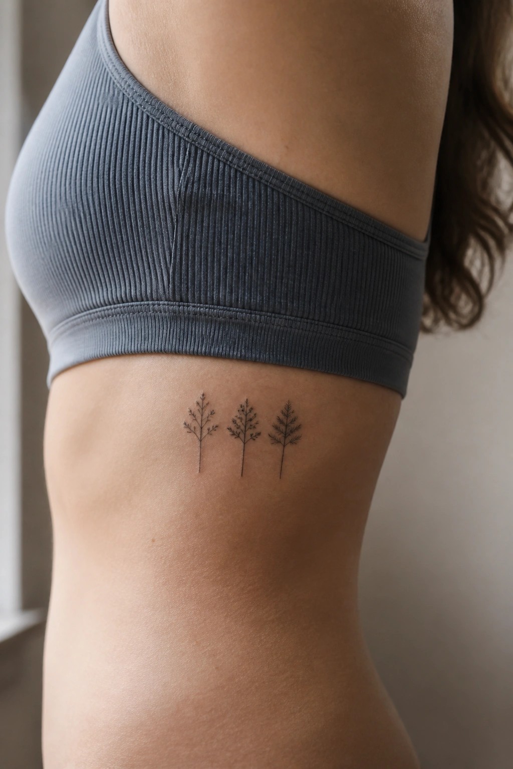 Gray ribbed crop top with three minimalist tree tattoos on ribcage