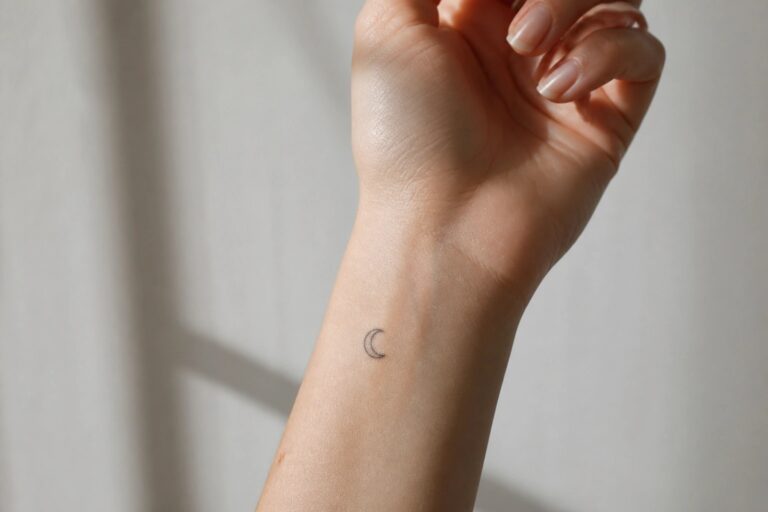 22 Minimalist Tattoo Ideas for Women Who Love Clean and Simple Ink Small crescent moon tattoo on the inner wrist of a hand with light skin.