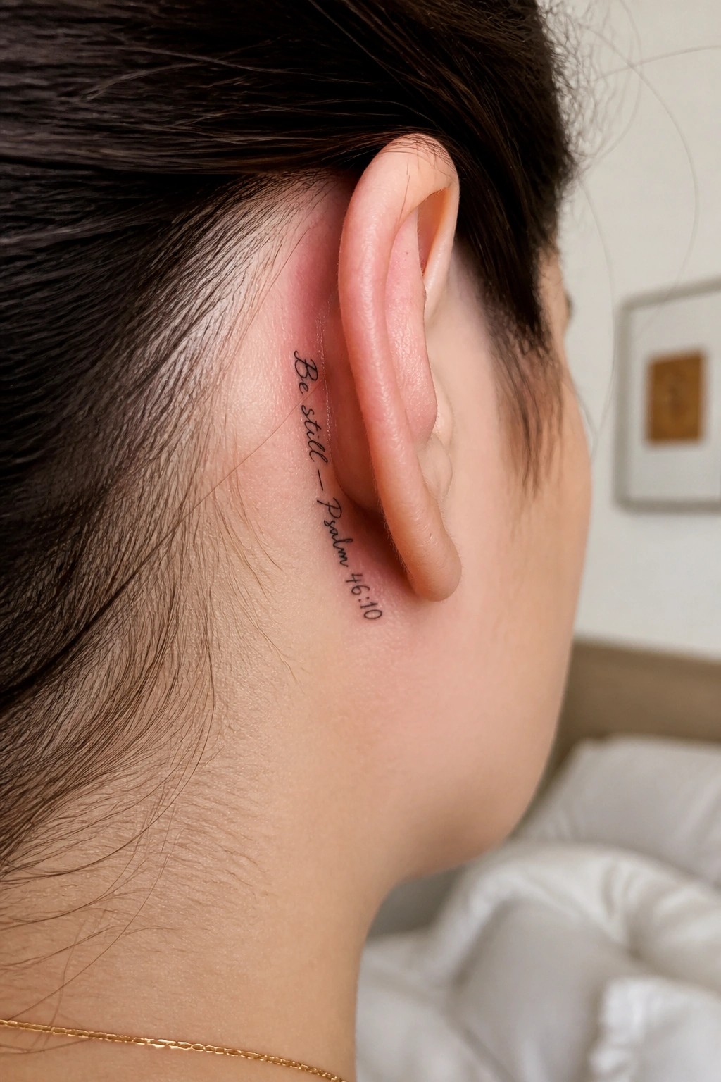 Woman's ear with cursive tattoo