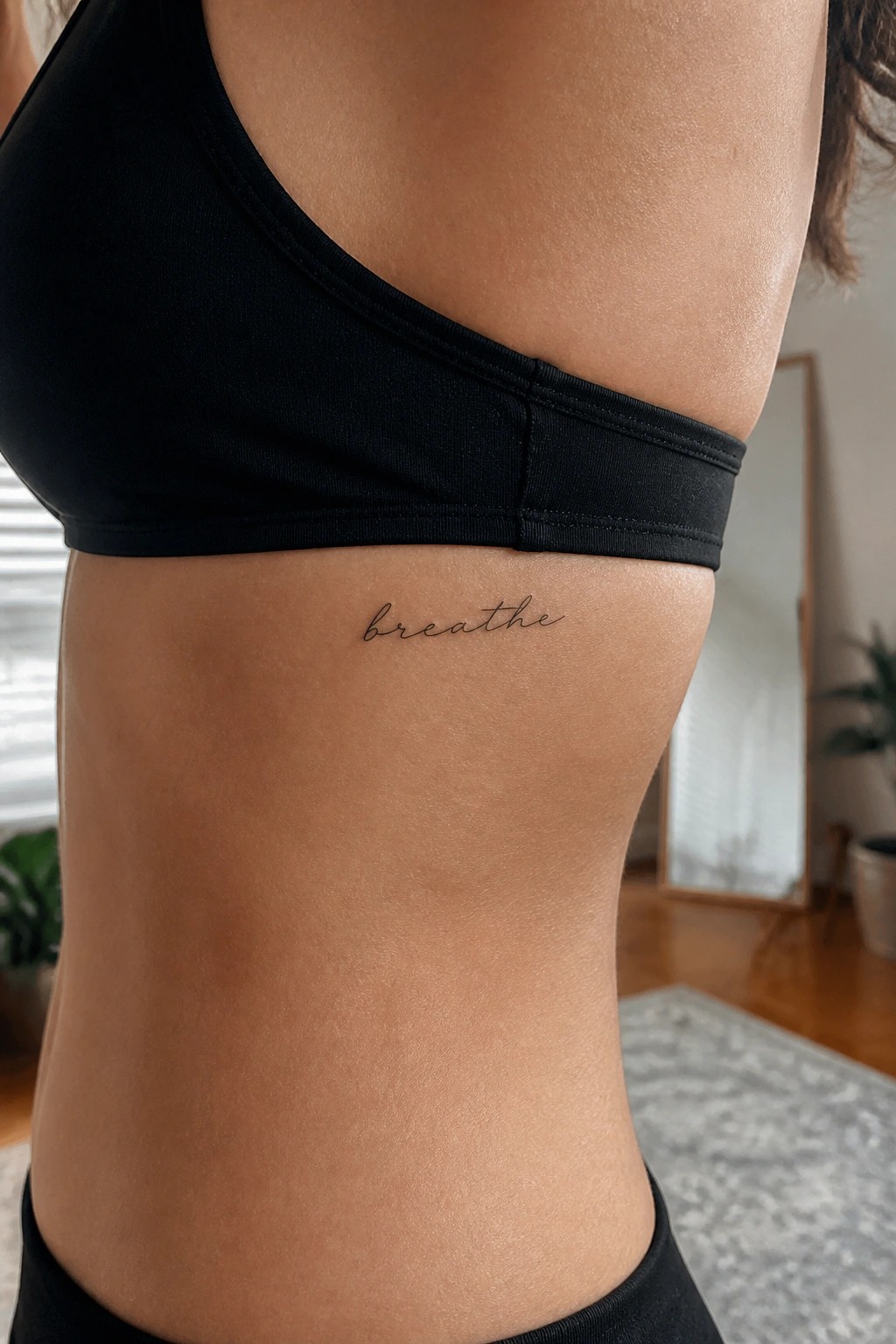 Torso in black sports bra with cursive