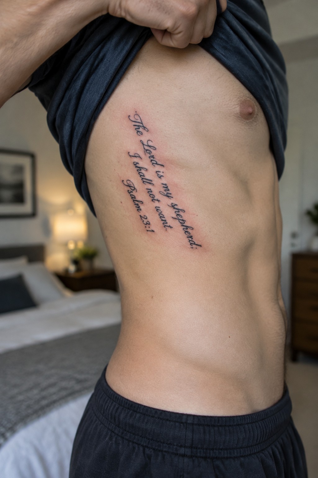 Shirt lifted to reveal Psalm 23:1 tattoo on side of torso in bedroom