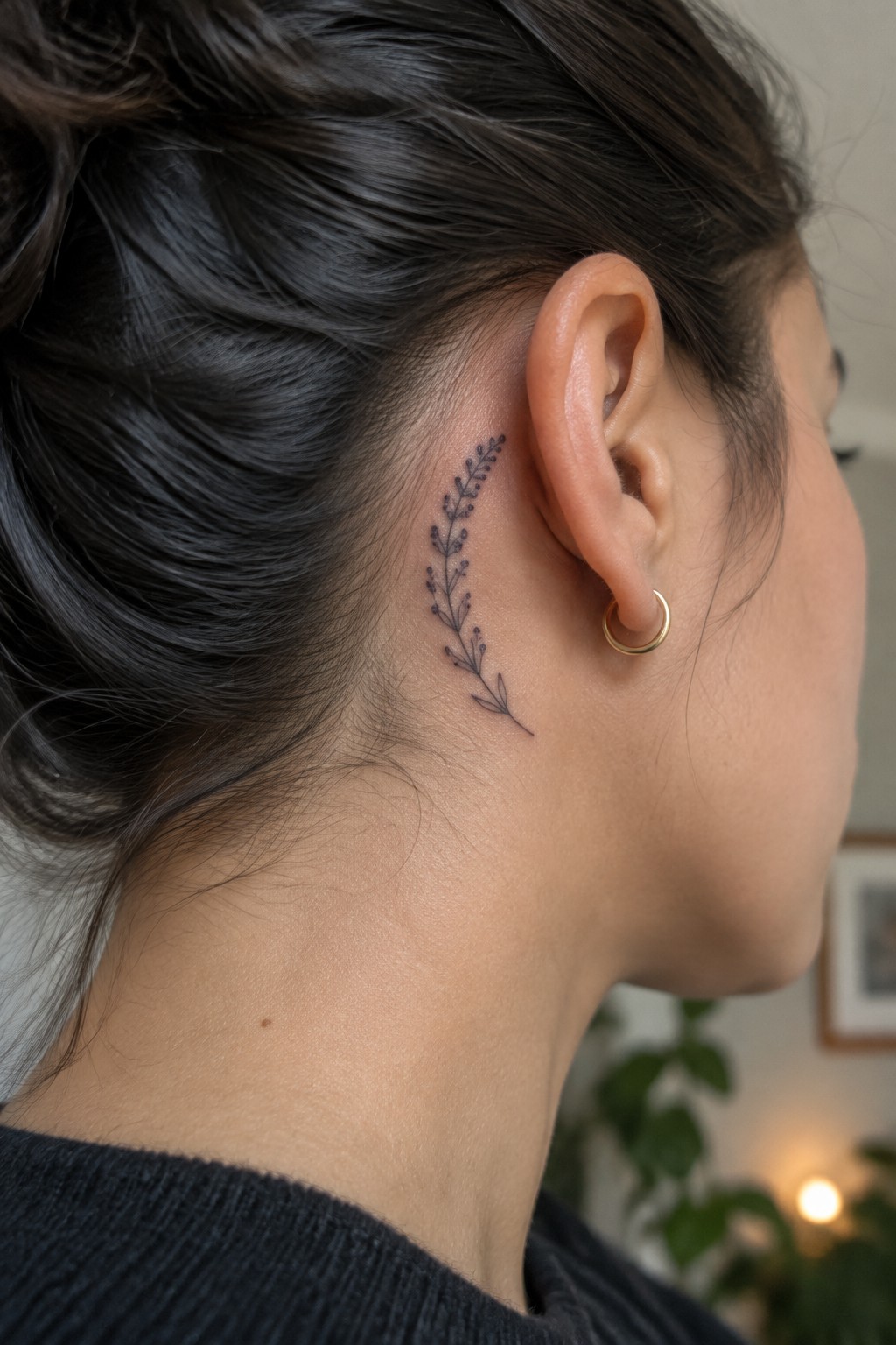 Fine line botanical sprig tattoo with dotted stems placed behind the ear on the side of the neck.