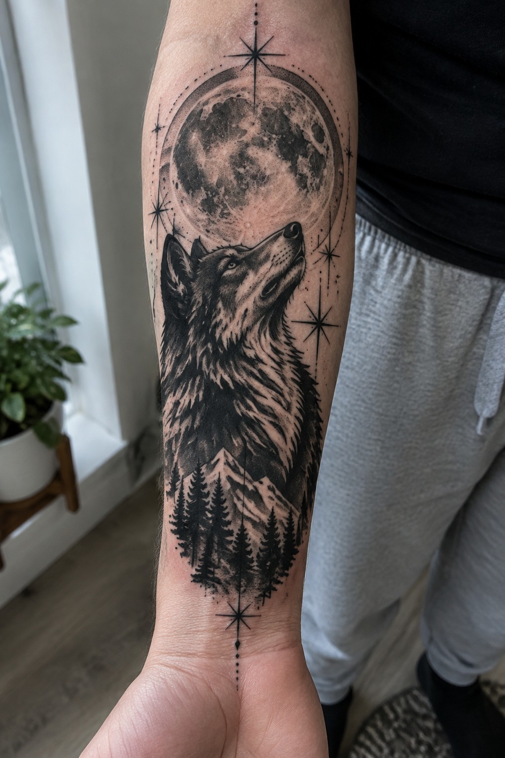 Black and gray wolf howling at full moon tattoo on forearm with stars and mountains