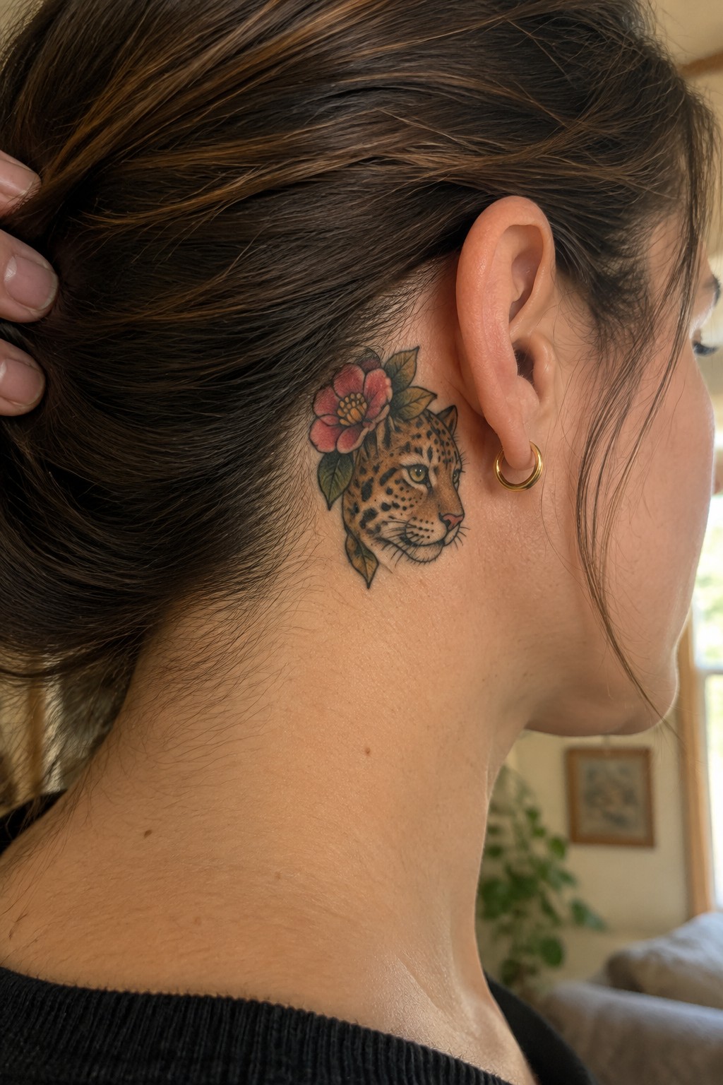 Neo traditional leopard head tattoo with a pink flower behind a woman's ear on the neck