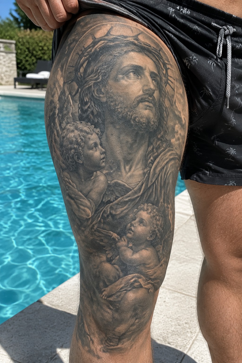 Realistic black and gray tattoo of Jesus with cherubs on thigh by pool