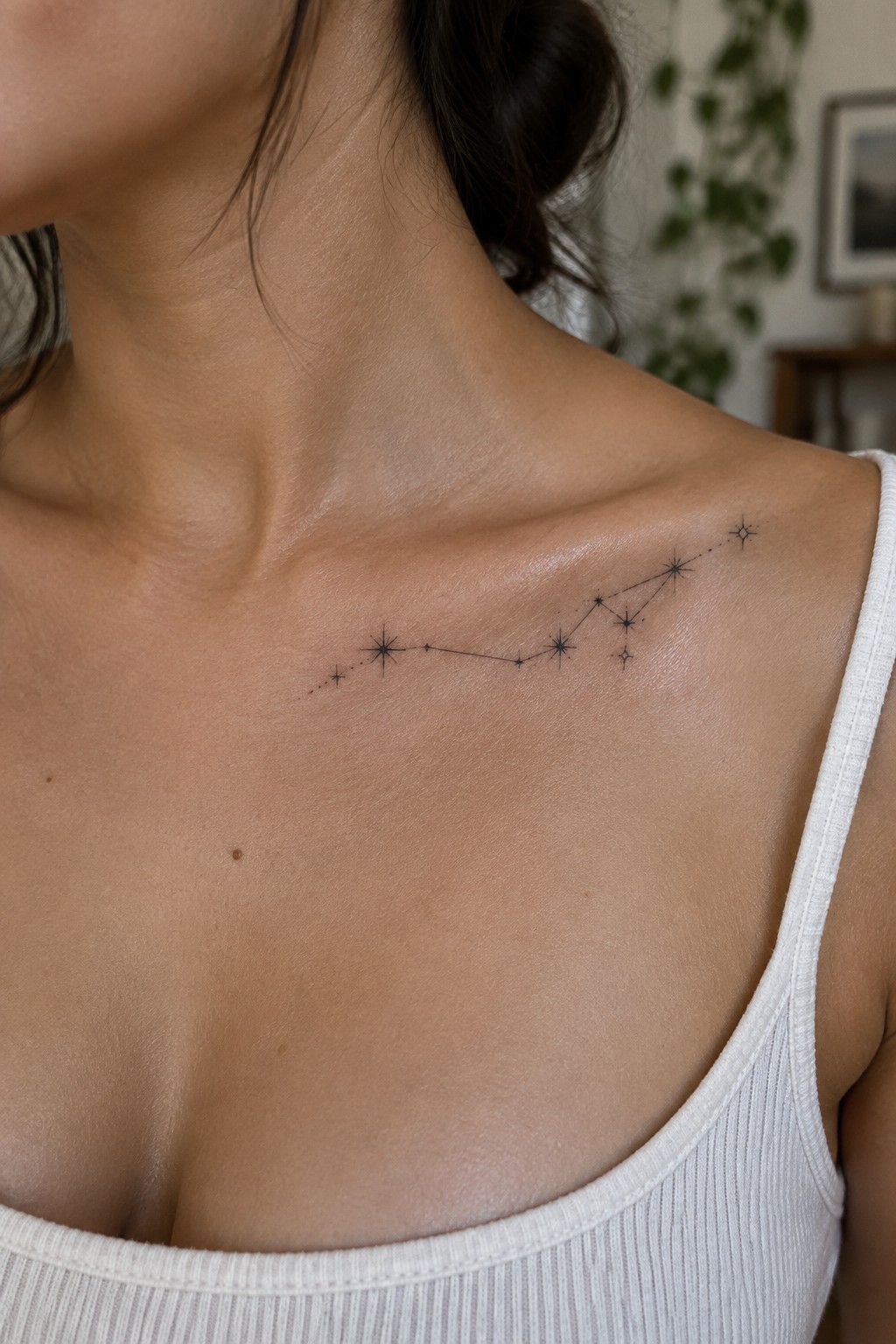 Constellation tattoo on shoulder above white ribbed tank top on light skin