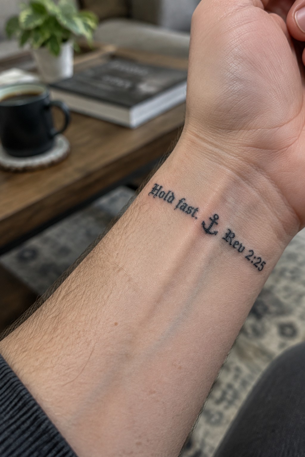 Wrist tattoo in black script: 