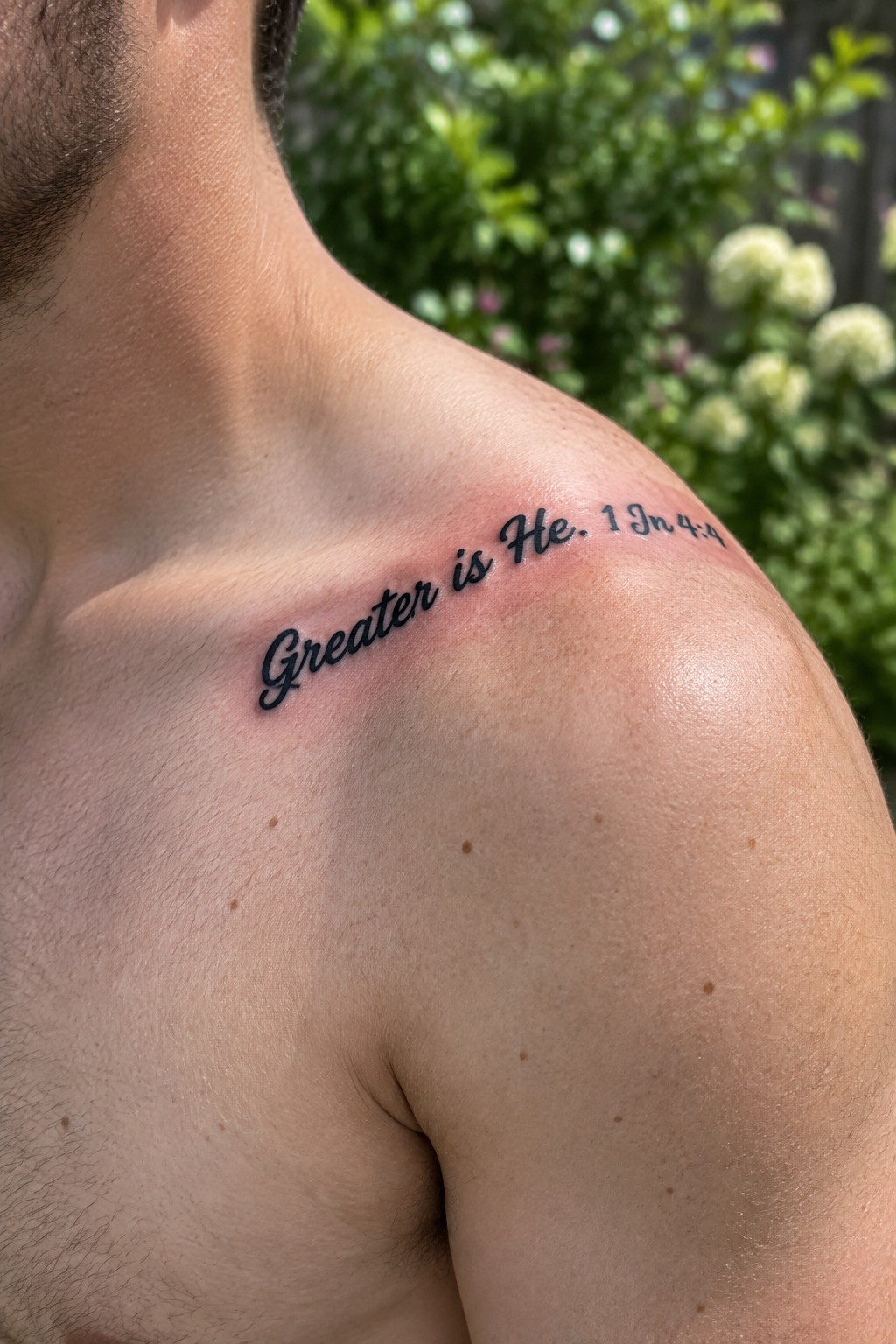 Shirtless man's shoulder with fresh red tattoo 