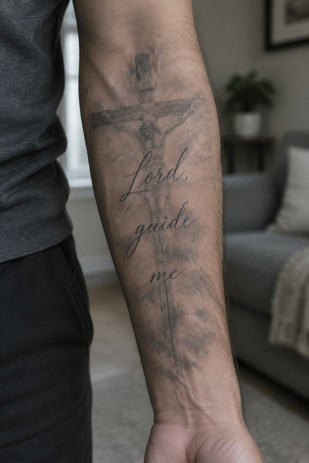 Person's forearm with crucifix tattoo and cursive 