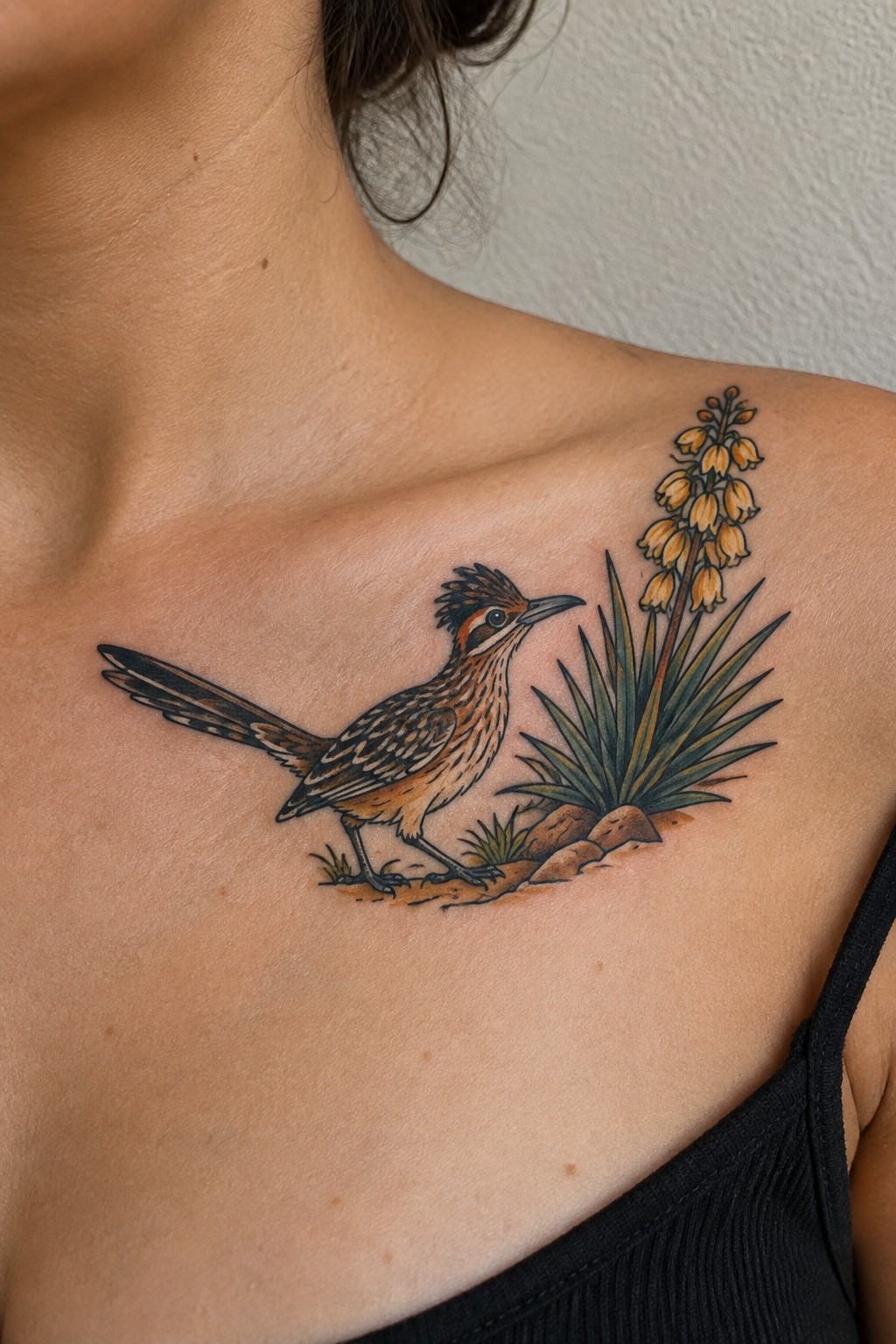 Detailed tattoo of roadrunner bird beside yellow-flowered desert plant on shoulder