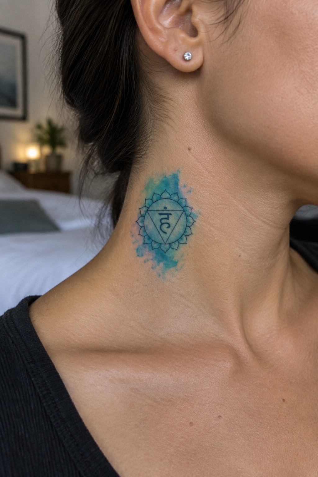 Blue watercolor chakra mandala tattoo on a woman's neck with earring