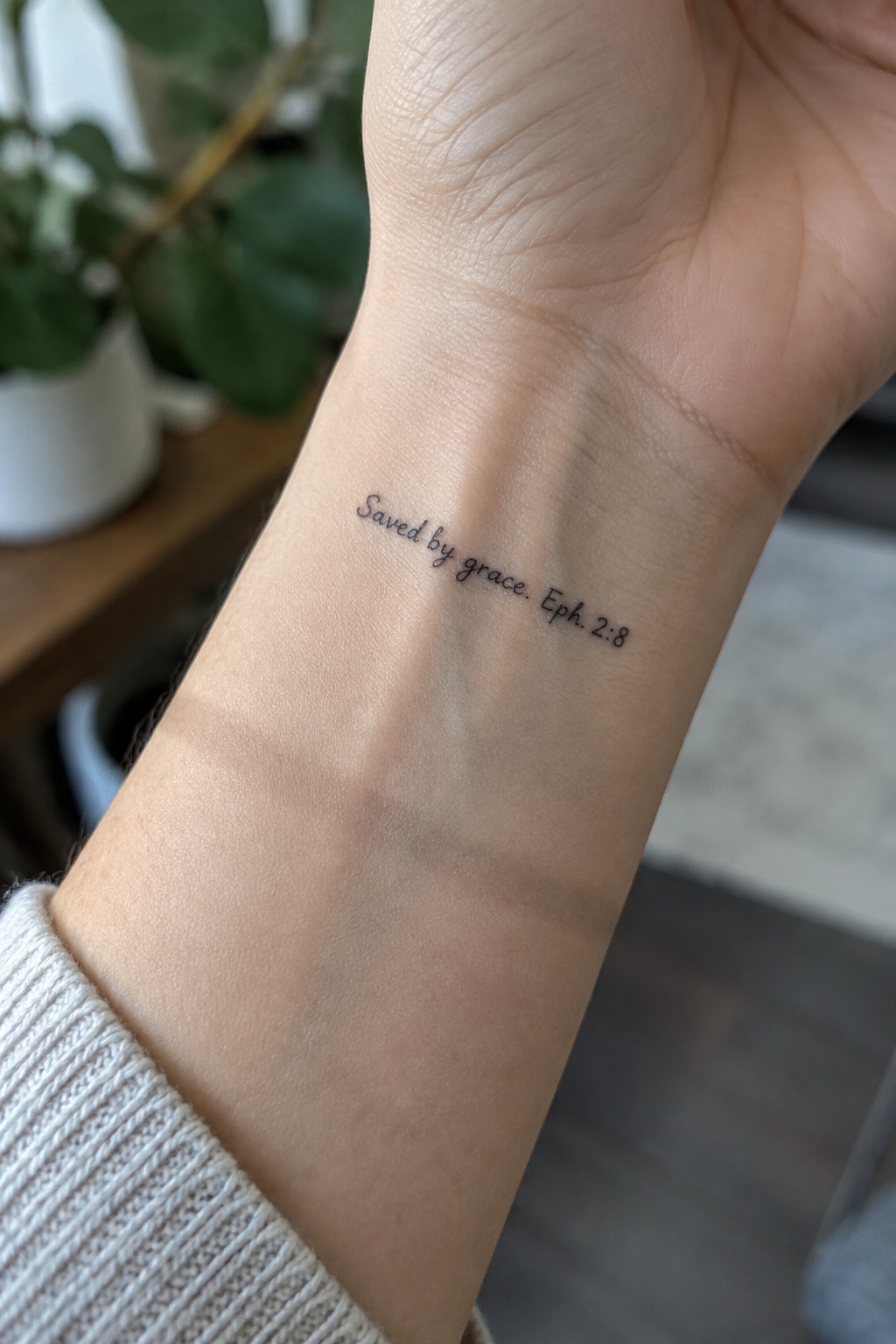 Wrist with black script tattoo