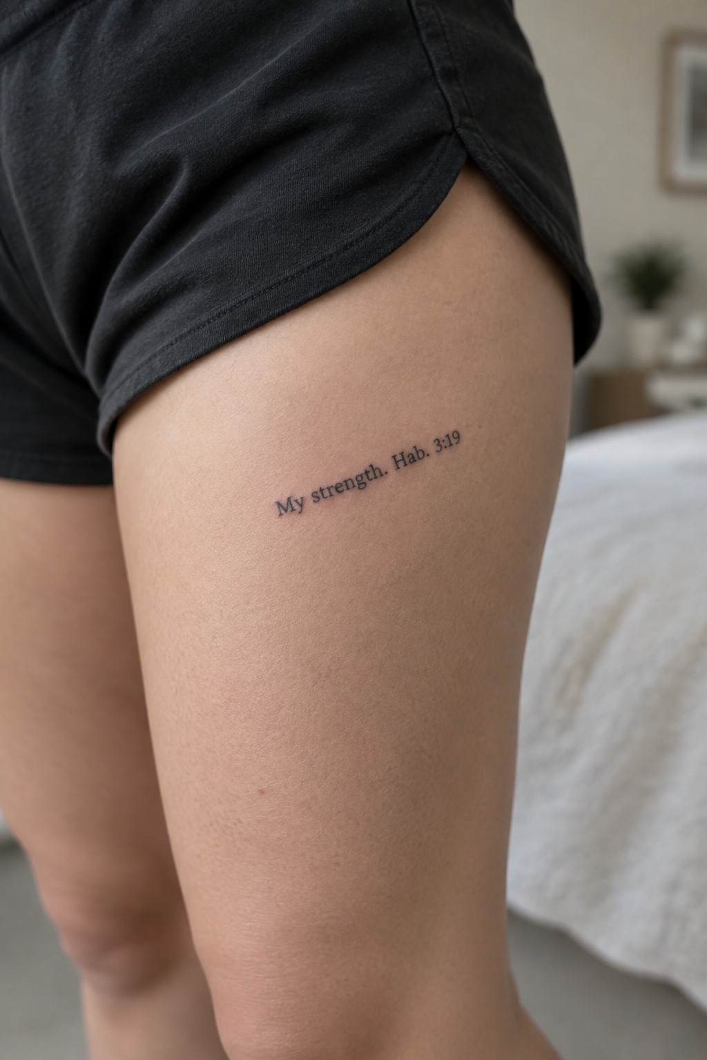 Small text tattoo on the upper thigh that reads
