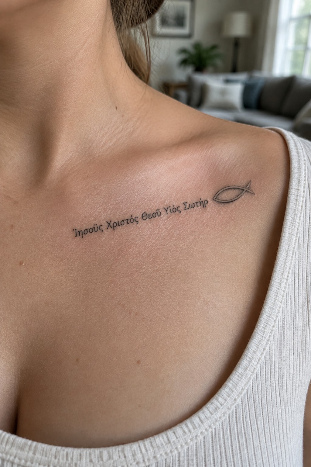 Shoulder tattoo with Greek text and fish symbol above white ribbed tank top