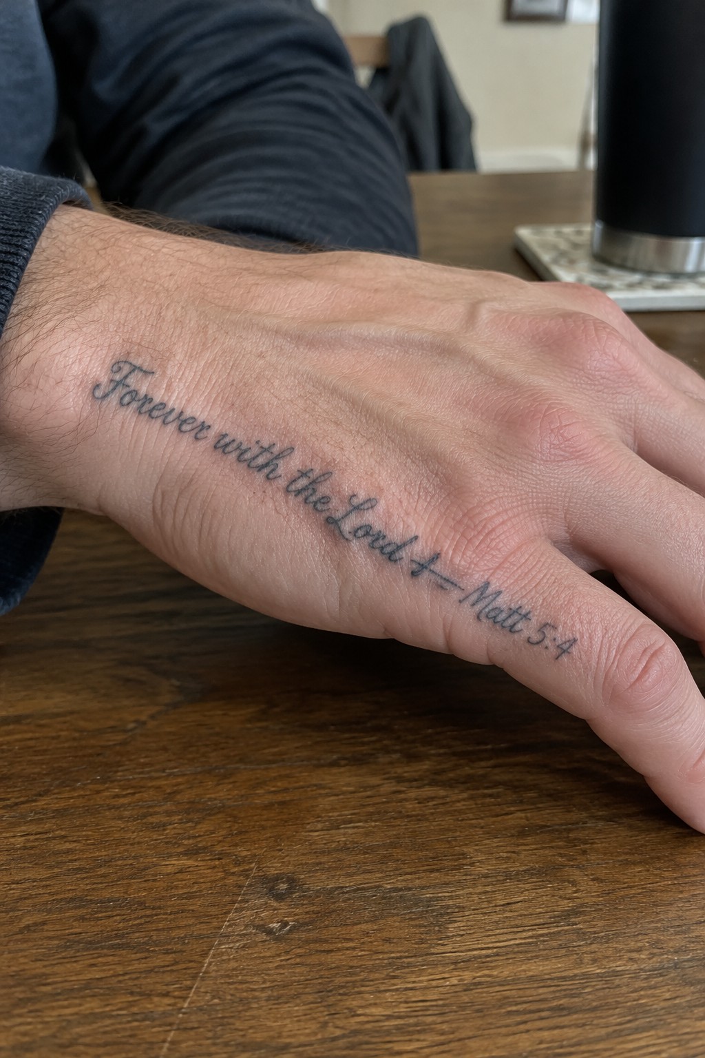 Hairy hand on wooden table with cursive