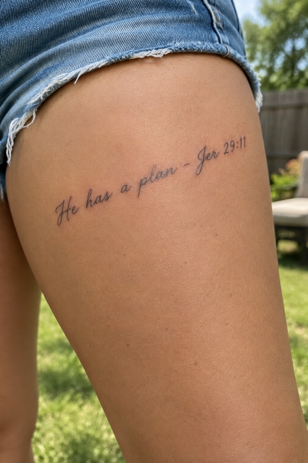 Frayed blue denim shorts on thigh with cursive