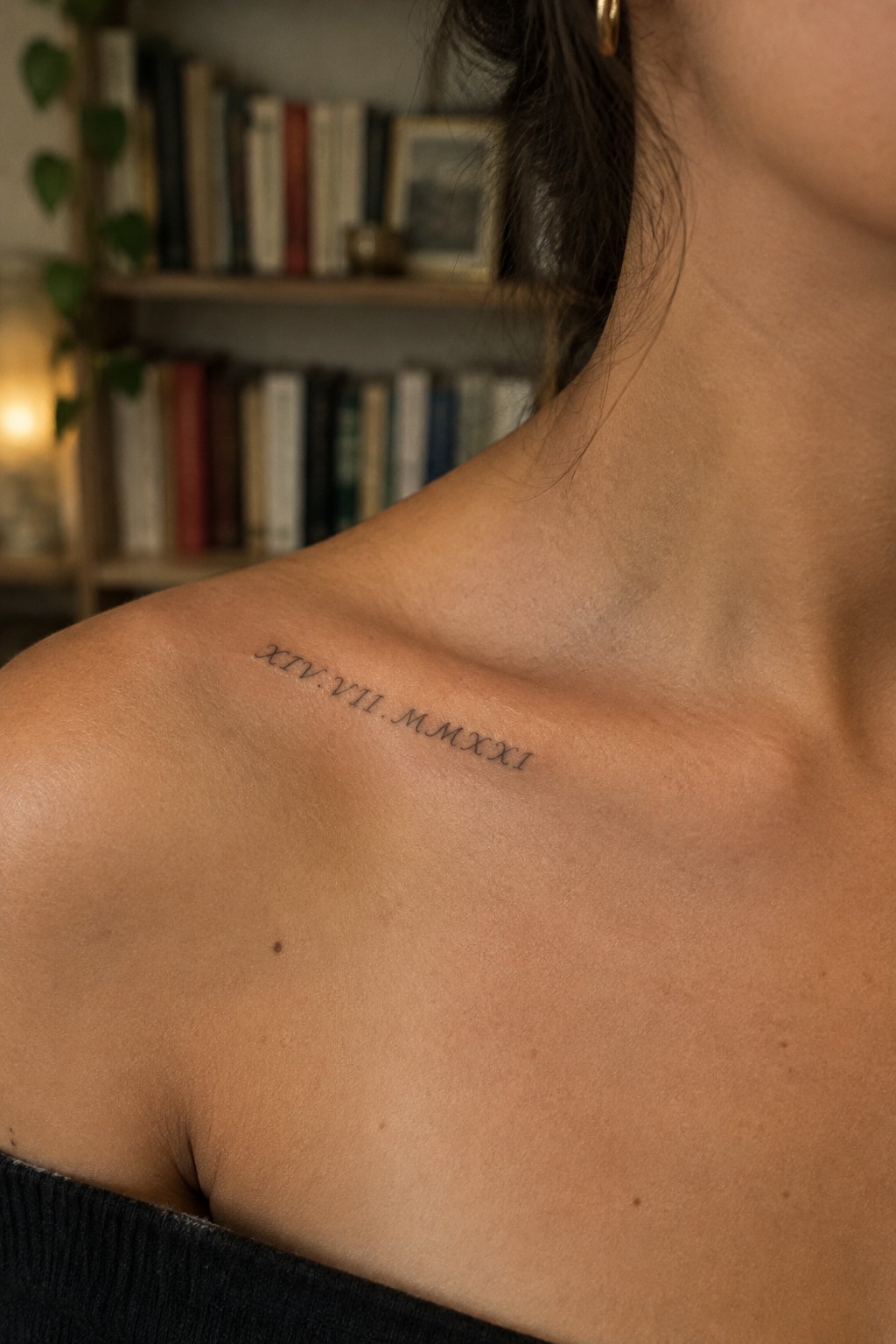 Fine-line Roman numeral date tattoo along a woman’s collarbone.