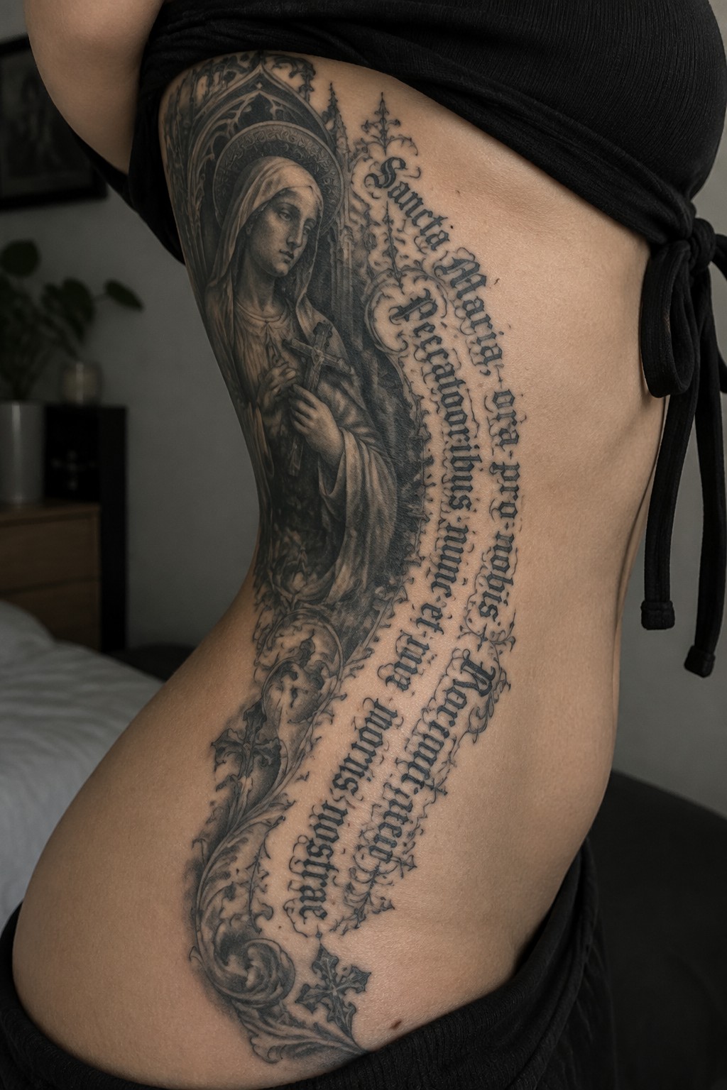 Large black and gray Virgin Mary tattoo with Latin text on side torso