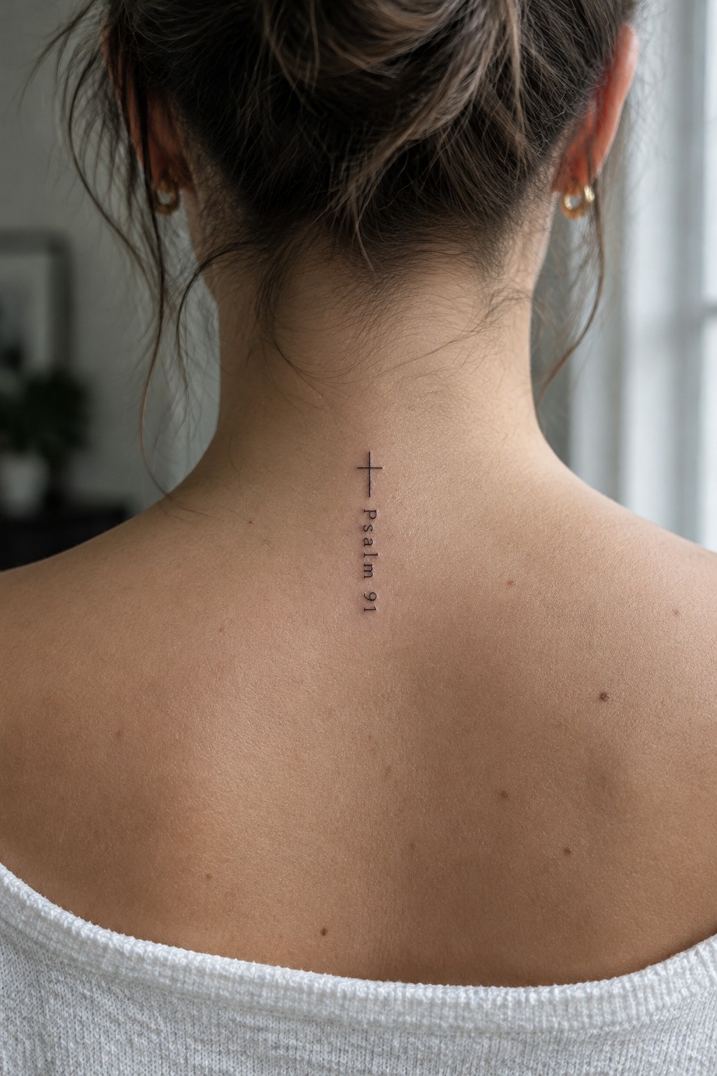 Woman's neck with vertical Psalm 91 tattoo and small cross above