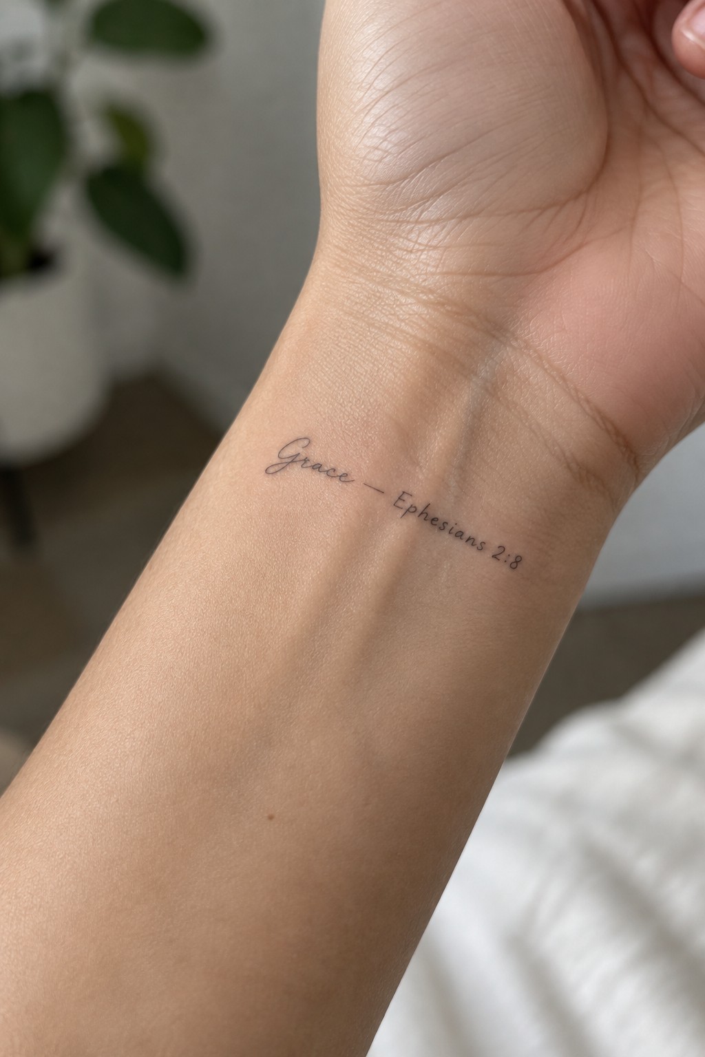 Wrist tattoo in black ink reading