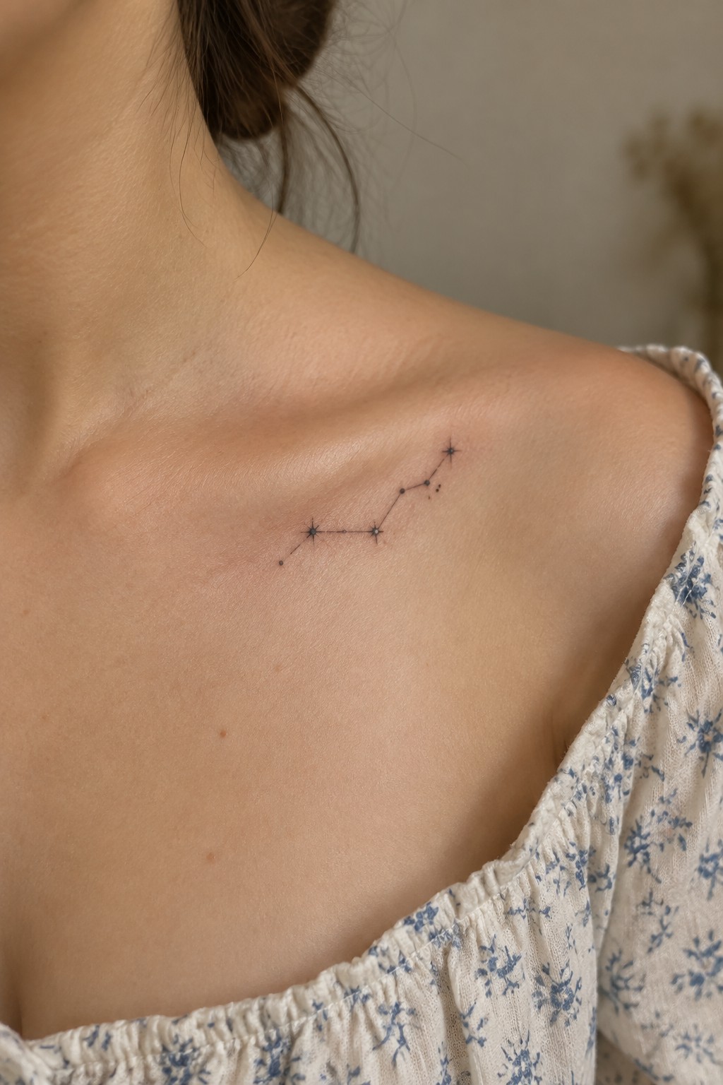 Small minimalist constellation tattoo with connected stars on a woman's shoulder