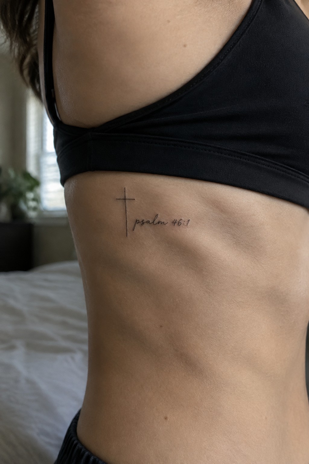 Black sports bra with cross and psalm 46:1 tattoo on ribcage