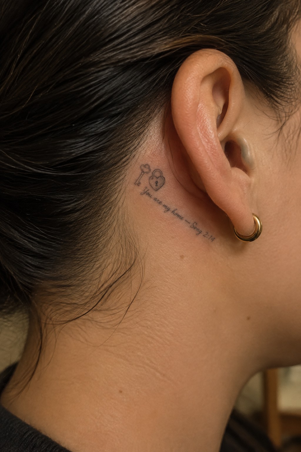 Small line tattoo behind the ear with a key, heart shaped lock, and the verse You are my home from Song 2:14