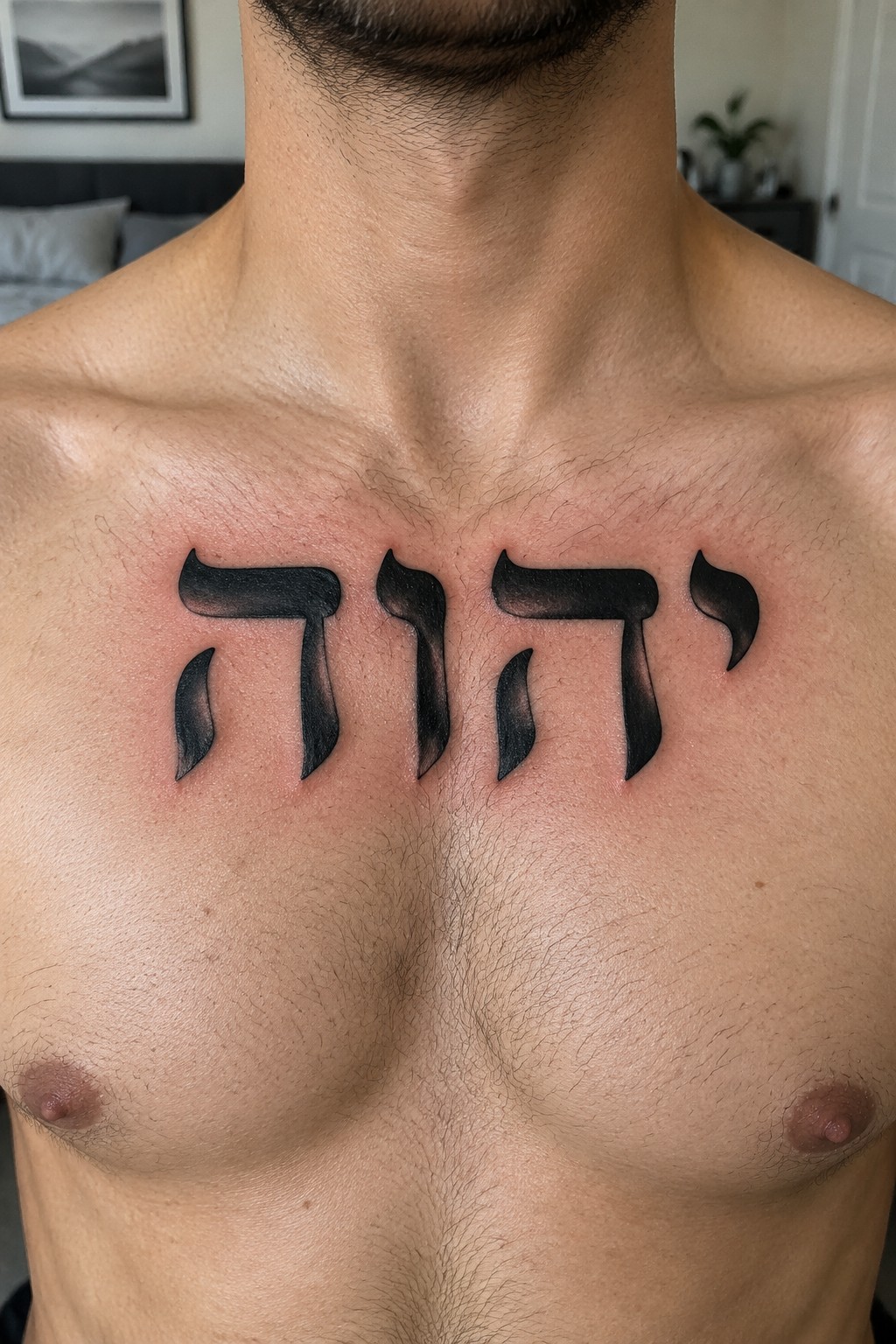 Black shaded Hebrew YHWH lettering tattoo centered on a man's upper chest