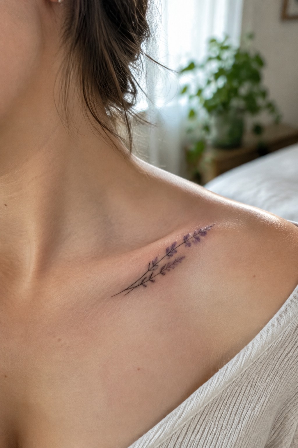 Delicate purple lavender tattoo on fair shoulder with white top and brown hair