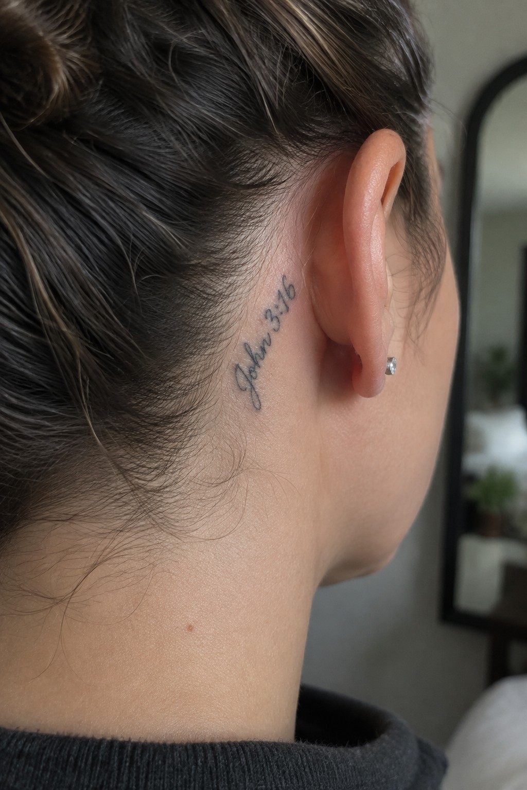 Dark-haired person in bun with cursive